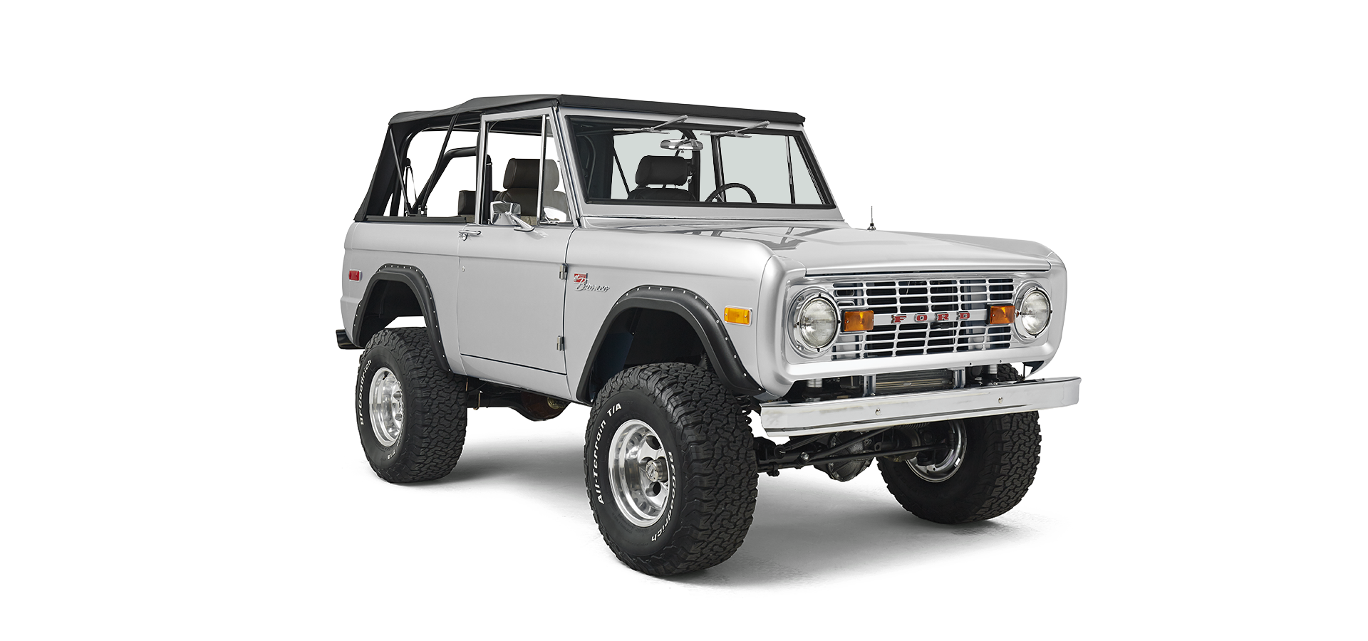 Silver Classic Ford Bronco with black soft top shown in front three-quarter view