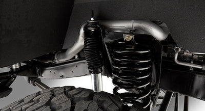 Close-up of suspension coil spring and shock absorber above tire in Classic Ford Bronco