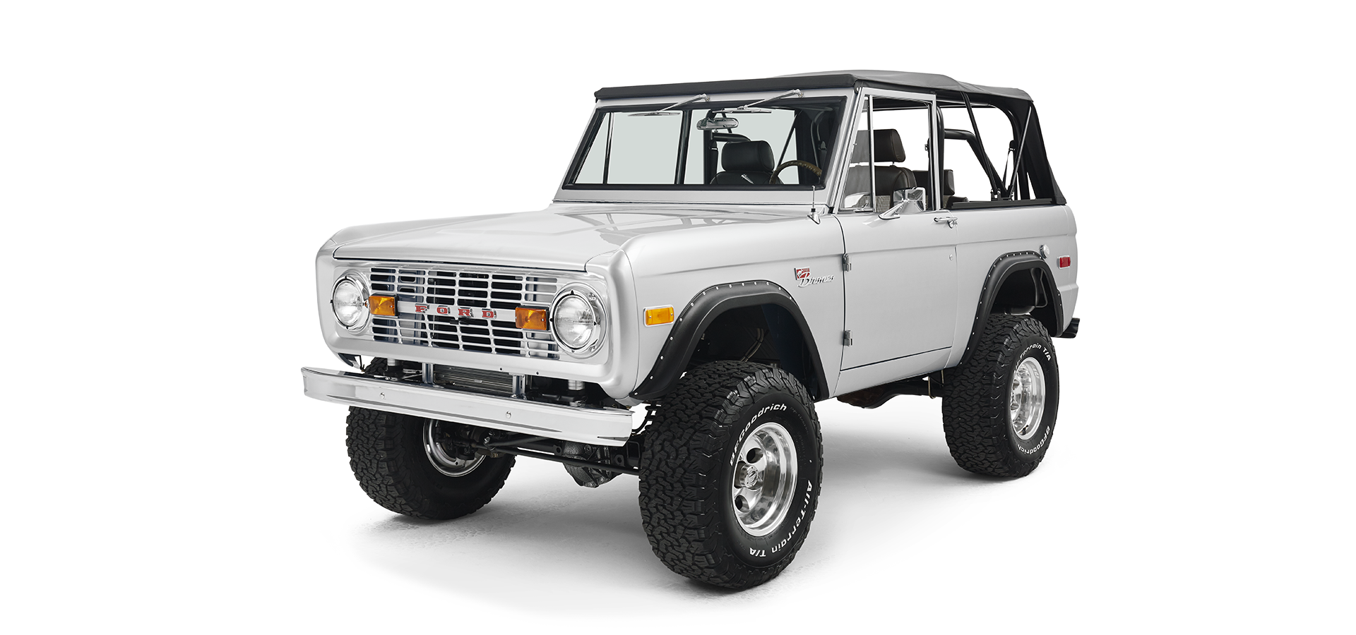 Silver Classic Ford Bronco front three-quarter view highlighting grille, tires, and soft top