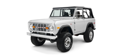 Silver Classic Ford Bronco front three-quarter view highlighting grille, tires, and soft top