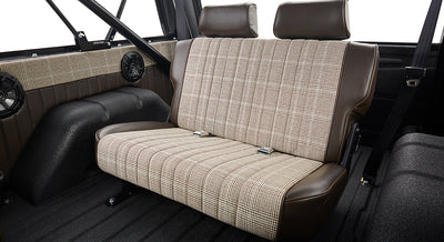 Rear bench seat with brown leather and plaid upholstery inside Classic Ford Bronco