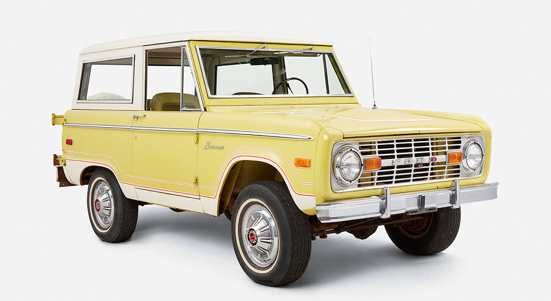 Yellow and white Classic Ford Bronco three-quarter view from front right