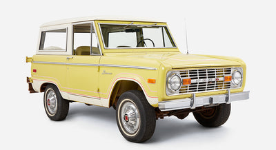 Yellow and white Classic Ford Bronco three-quarter view from front right