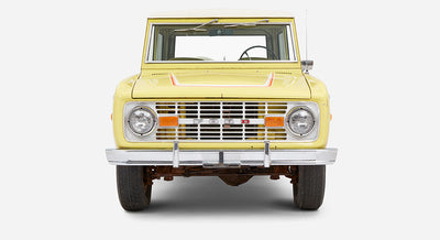 Front view of yellow Classic Ford Bronco with chrome bumper and headlights