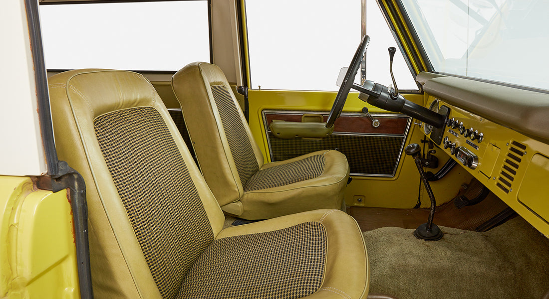 Classic Ford Bronco interior featuring yellow and black houndstooth seats and yellow door panel