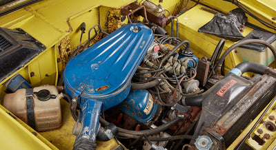 Close-up of Classic Ford Bronco engine bay showing blue air filter cover and surrounding components