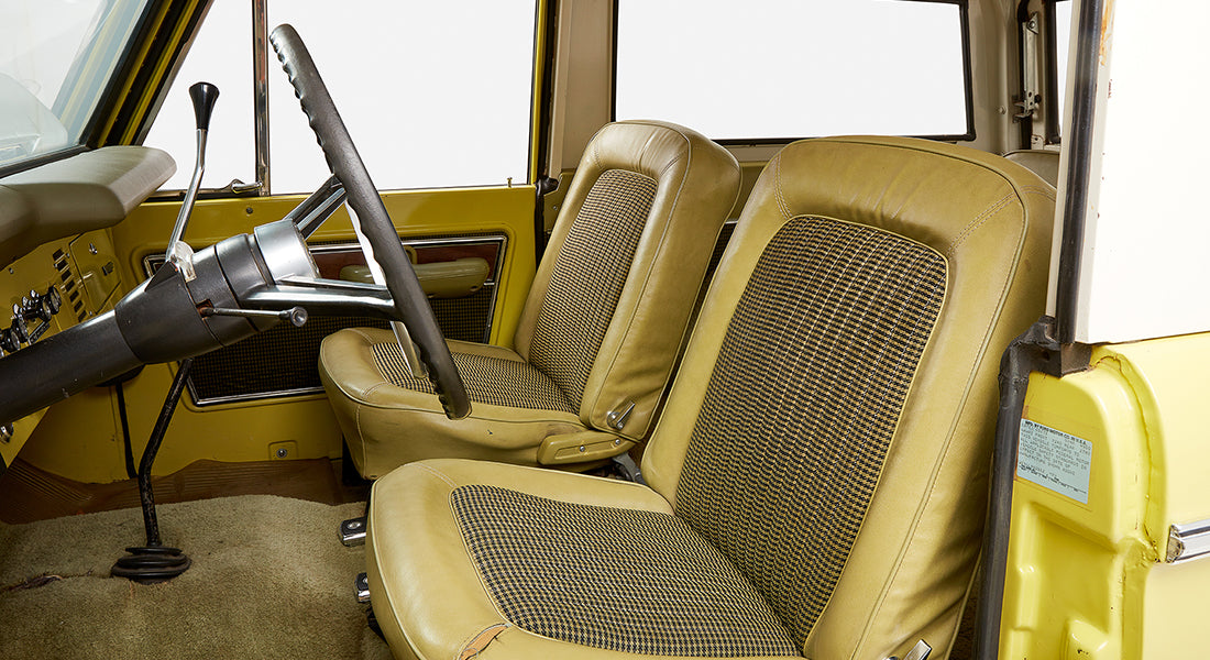 Classic Ford Bronco front interior seats with yellow and black houndstooth upholstery and steering wheel
