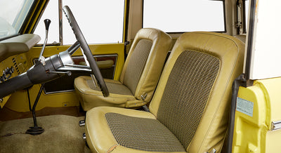 Classic Ford Bronco front interior seats with yellow and black houndstooth upholstery and steering wheel