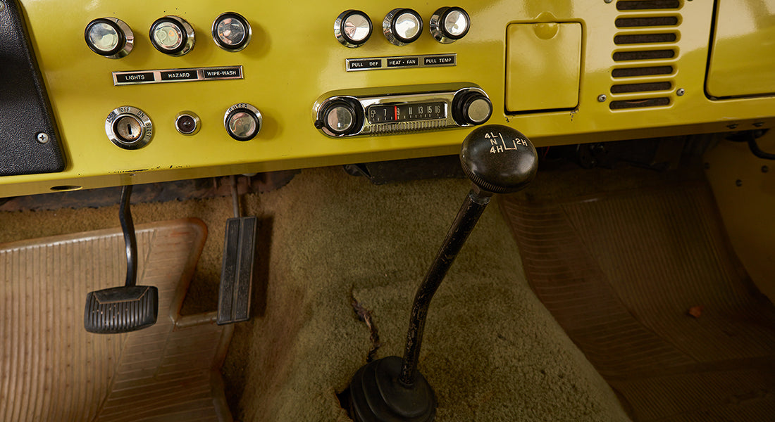 Interior dashboard controls and knobs of yellow Classic Ford Bronco