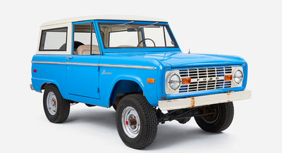 Classic Ford Bronco in blue with white roof viewed from front left side