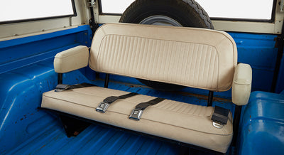 Interior rear seating area of Classic Ford Bronco with beige bench seat and armrests