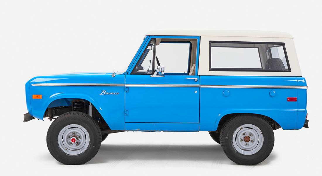 Right side profile of blue Classic Ford Bronco with white roof