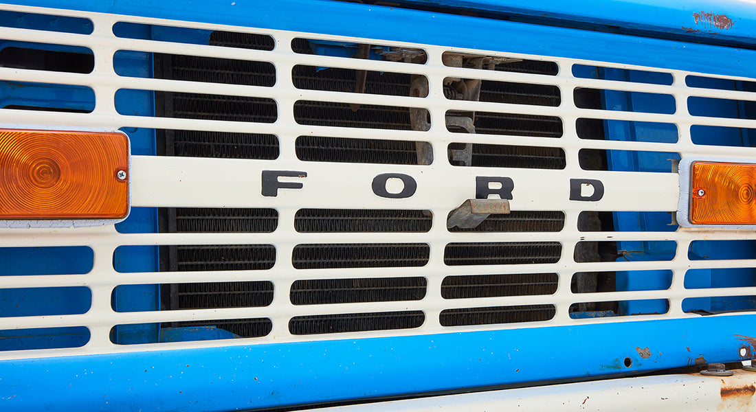 Front grill of Classic Ford Bronco with blue and white color and orange signals