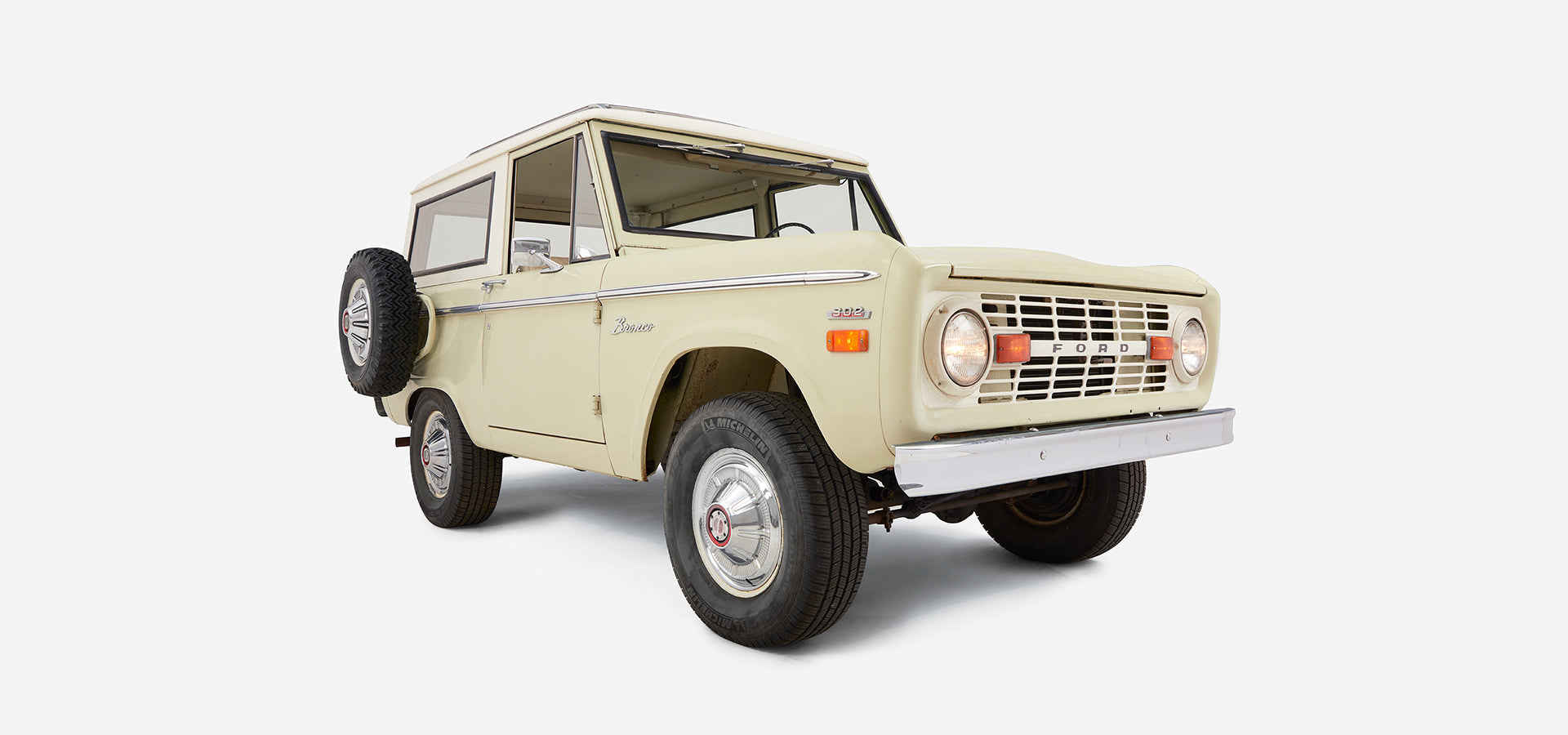 Rear three-quarter view showing right side and back of Classic Ford Bronco with white cab and sage body