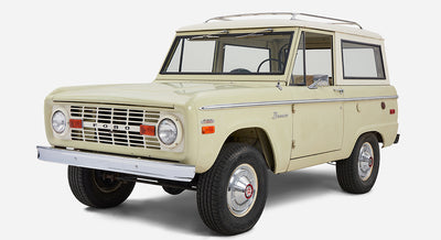 Classic Ford Bronco angled front view showing white and sage paint with chrome bumper