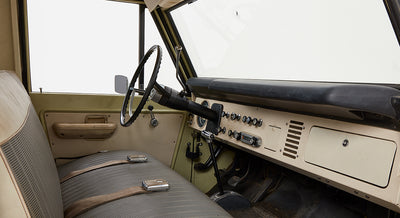 Classic Ford Bronco interior front cabin with steering wheel, gear shifters, and dashboard controls