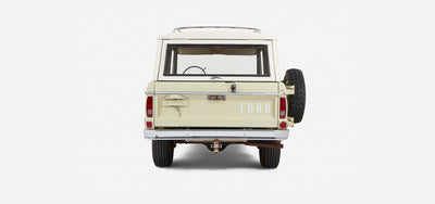 Classic Ford Bronco in light yellow with white roof viewed from the rear