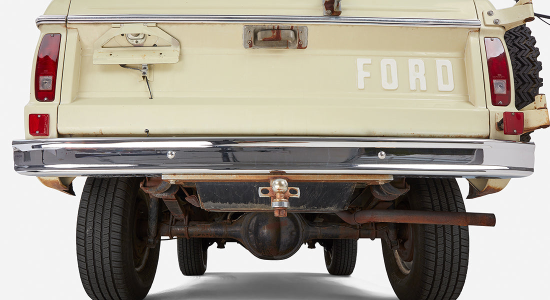 Rear of Classic Ford Bronco showing tailgate with FORD lettering and chrome bumper with tow hitch