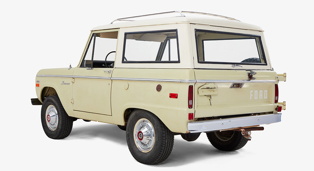 Classic Ford Bronco rear three-quarter view highlighting spare tire and sage-white paint