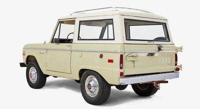 Classic Ford Bronco rear three-quarter view highlighting spare tire and sage-white paint