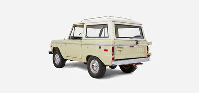 Rear three-quarter view of Classic Ford Bronco with white cab and sage body on white background
