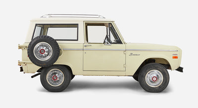 Side view of Classic Ford Bronco showing two doors, spare tire mounted on back, and mid-size SUV profile