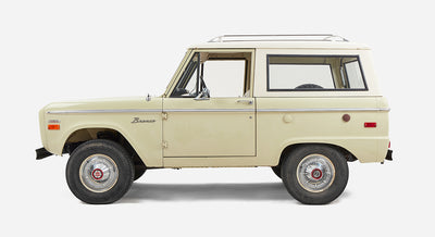 Profile side view of a Classic Ford Bronco with white cab and sage body on white background