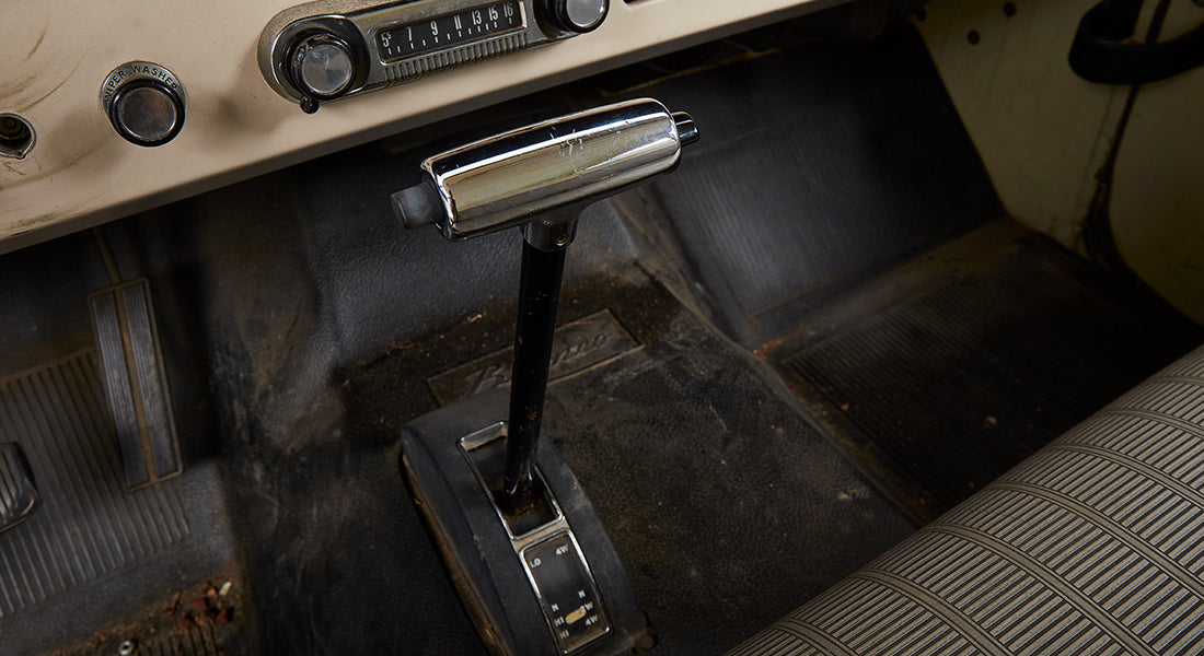 Classic Ford Bronco interior floor and gear shift lever with radio and control knobs on dashboard