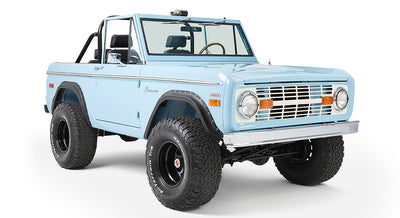 Classic Ford Bronco baby blue front three-quarter view featuring round headlights and lifted suspension.