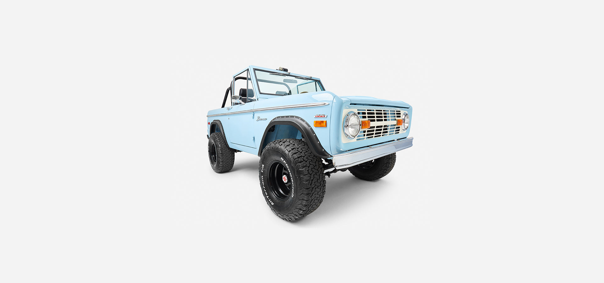 Front three-quarter view of a baby blue Classic Ford Bronco on a white background