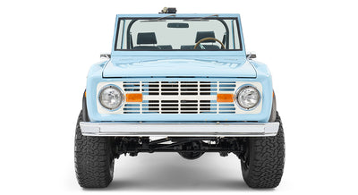 Classic Ford Bronco baby blue front view showing the grille, headlights, and bumper.