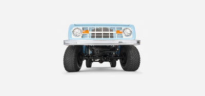 Underside view of baby blue Classic Ford Bronco showing suspension and front wheels