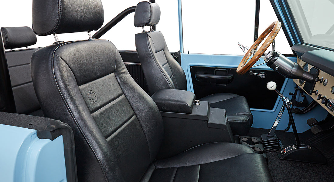 Classic Ford Bronco interior with black leather seats and wood steering wheel