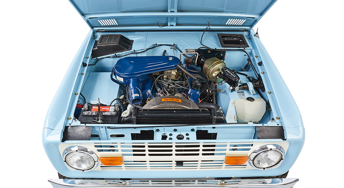 Front view of baby blue Classic Ford Bronco engine and radiator with open hood