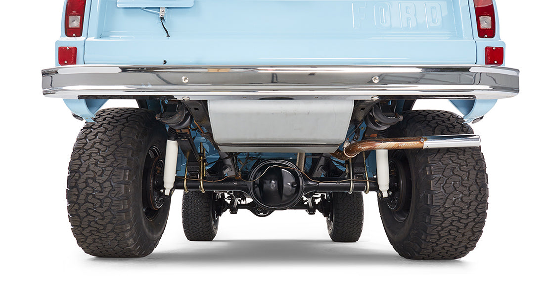 Rear underside view of classic Ford Bronco baby blue showing exhaust, differential, and suspension components.