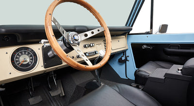 Wooden steering wheel and dashboard with gauges inside Classic Ford Bronco