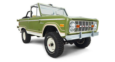 Three-quarter front view of a green and white Classic Ford Bronco with off-road tires.