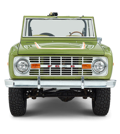 Front view of green Classic Ford Bronco with headlights and Ford grille visible.