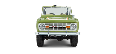 Front view of green and white Classic Ford Bronco with two round headlights and no roof.