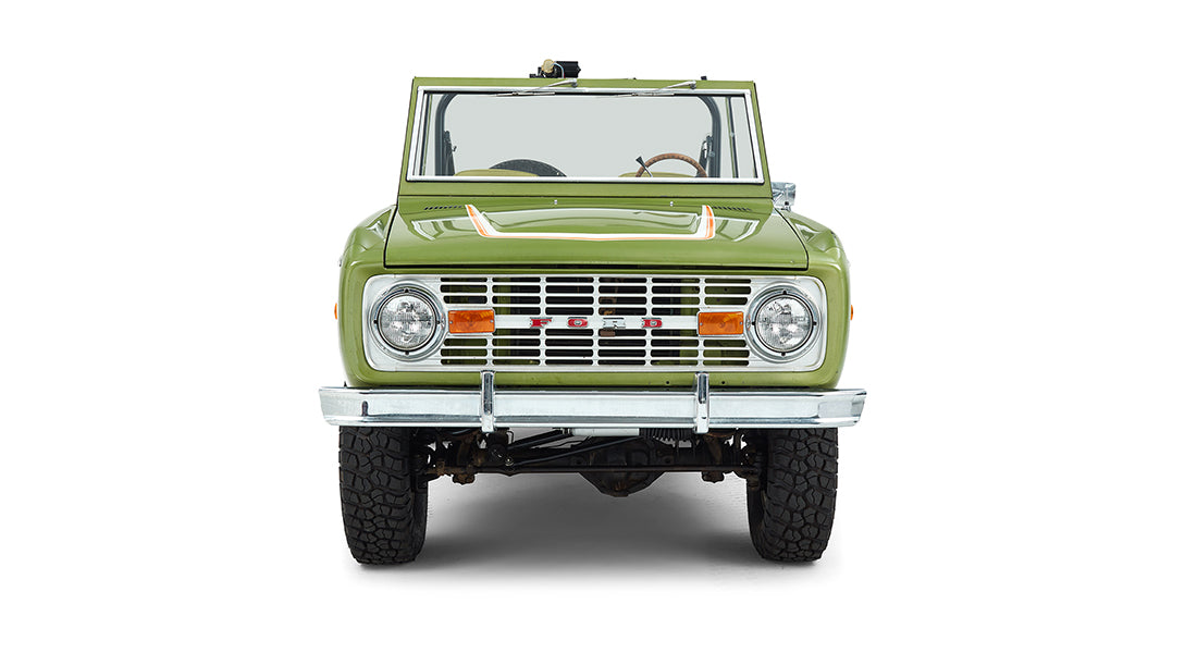 Front view of a green Classic Ford Bronco showing its grille and headlights