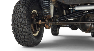 Close-up of the rear axle, coil spring suspension, and off-road tire of a Classic Ford Bronco