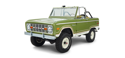 Three-quarter front view of a green and white Classic Ford Bronco angled to the left with no roof.