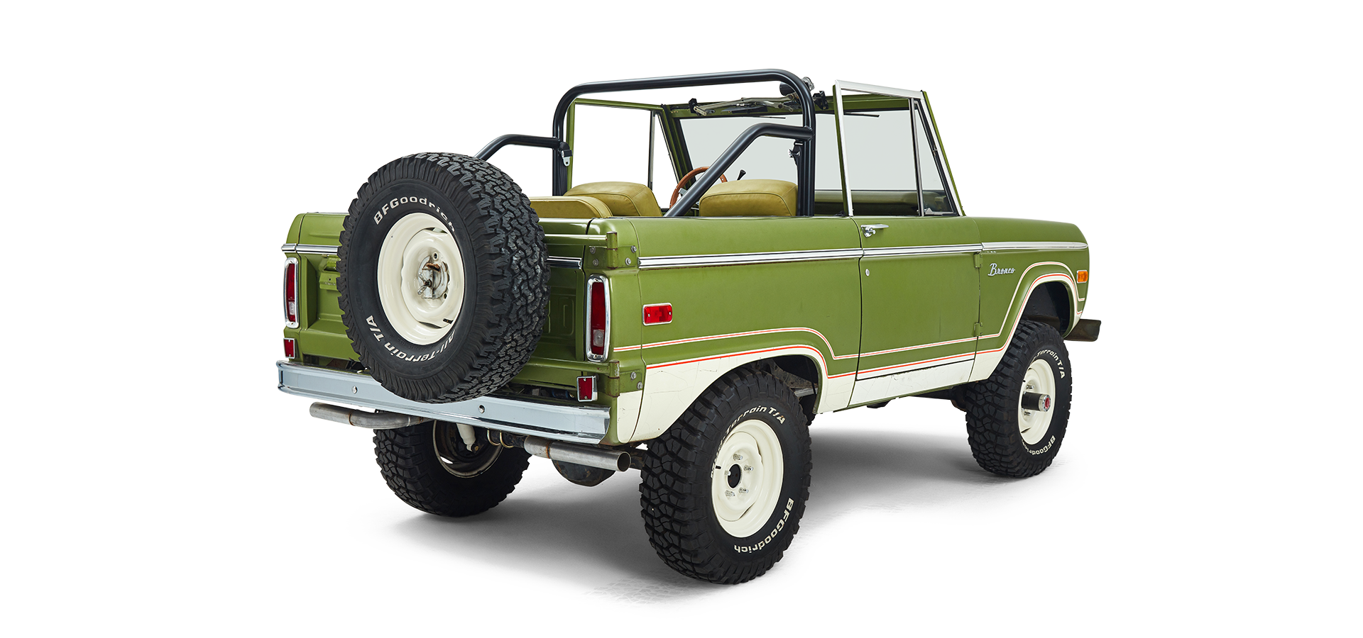 Three-quarter rear view of a green and white Classic Ford Bronco showing spare tire and roll bar.