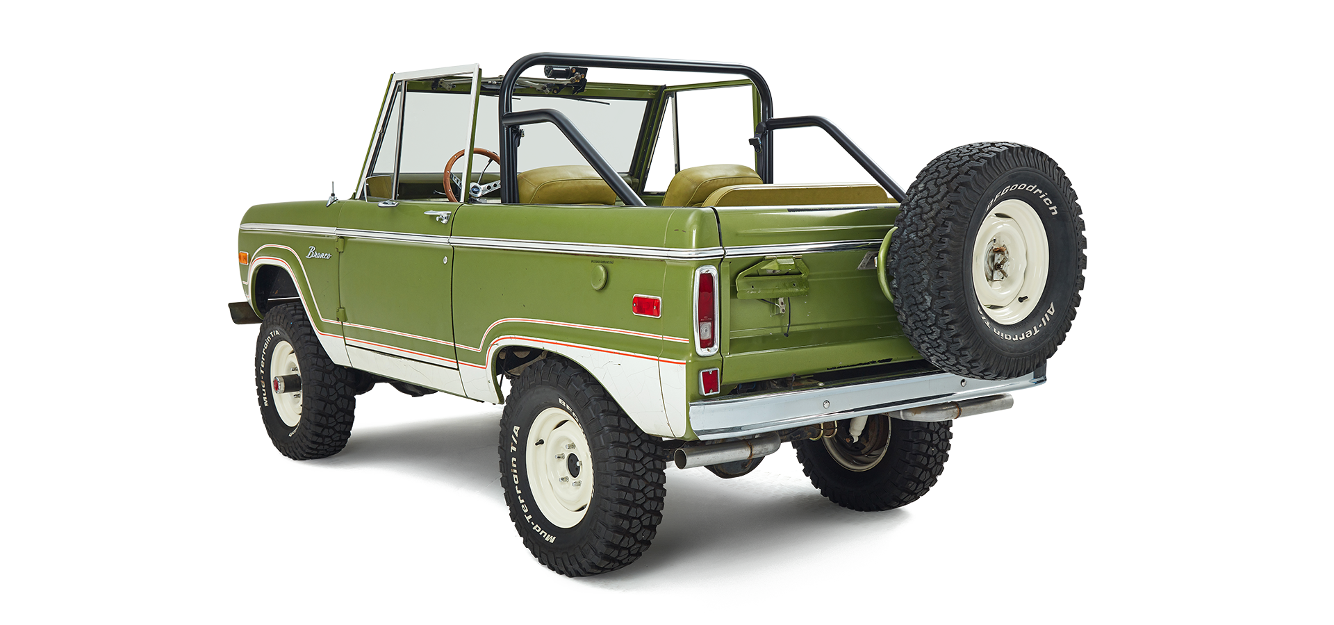 Three-quarter rear view of a green and white Classic Ford Bronco angled to the right with off-road tires.
