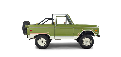Side profile of a green and white Classic Ford Bronco with off-road tires and roll bar.