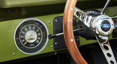 Close-up of a Classic Ford Bronco's dashboard and wooden steering wheel with Ford logo