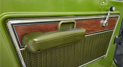 Detailed view of the passenger side door panel and armrest in a green Classic Ford Bronco