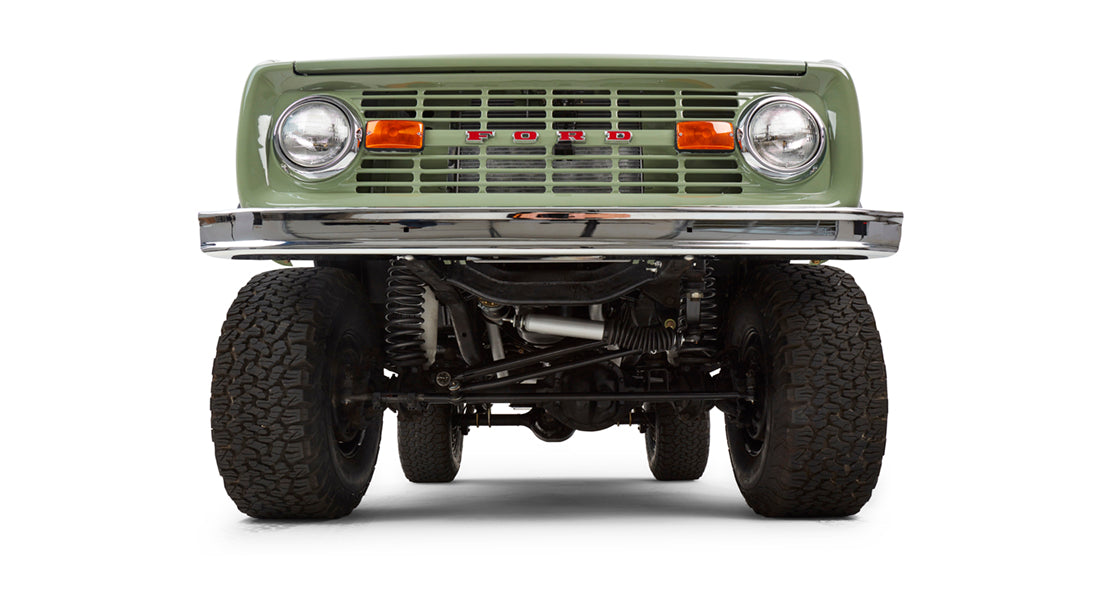 Front view of lifted Classic Ford Bronco with green grille, headlights, and bumper