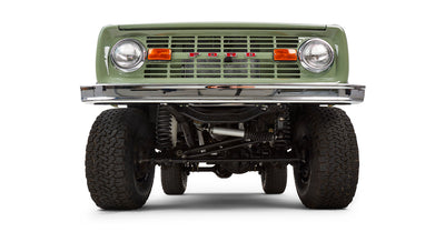 Front view of lifted Classic Ford Bronco with green grille, headlights, and bumper