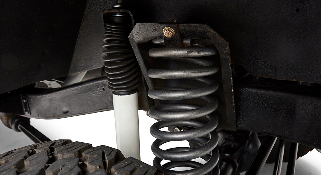 Close-up of black coil spring suspension and white shock absorber on Classic Ford Bronco